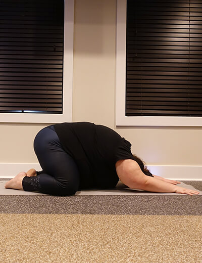 plus size woman doing yoga childs pose