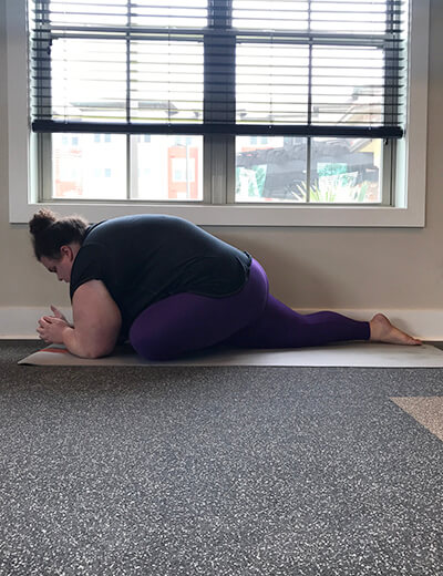 plus size woman doing yoga pigeon