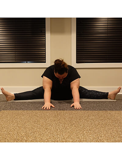 plus size woman doing yoga forward fold