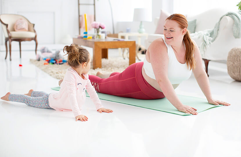 Mom practicing yoga with daughter.