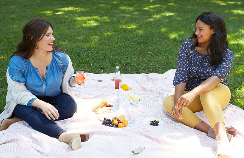 Plus size models having a picnic in the park.
