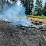 Firefighters extinguish log pile fire in Hosmer