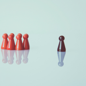 gamepieces on an off-white background, with a black piece leading a group of red pieces