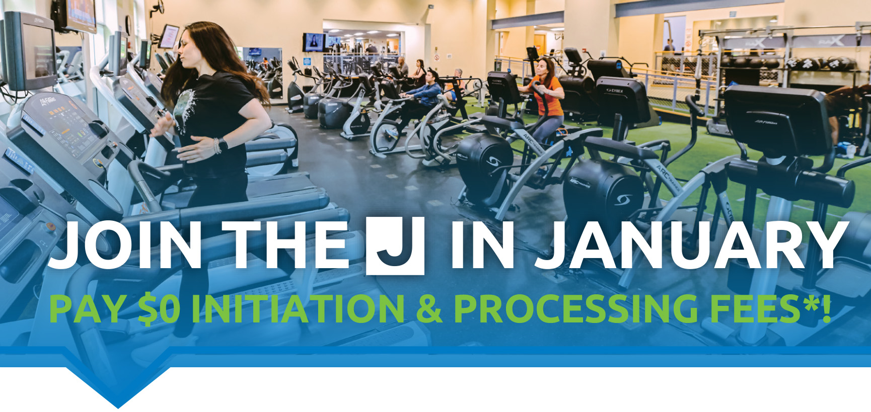 People exercising on cardio machines in a gym with a large banner that says, "Join the J in January. Pay $0 initiation & processing fees*.