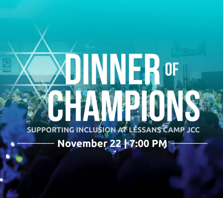 A large crowd sits at decorated tables under blue lighting for the "Dinner of Champions" event, held November 22 at 7:00 PM in support of inclusion at Lessans Camp JCC.