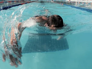 A man in a pool swimming.