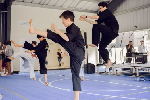 A group of boys kicking into the air as a karate move.