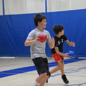 Two boys playing dodgeball.