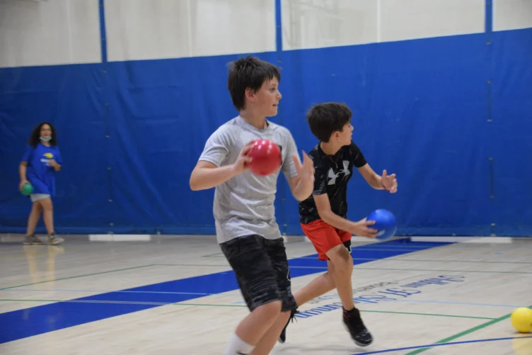 Two boys playing dodgeball.