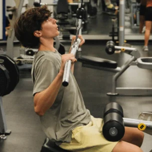 A teenage boy using a lat pulldown machine.