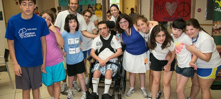 A group of kids and teenagers smiling for a photo.