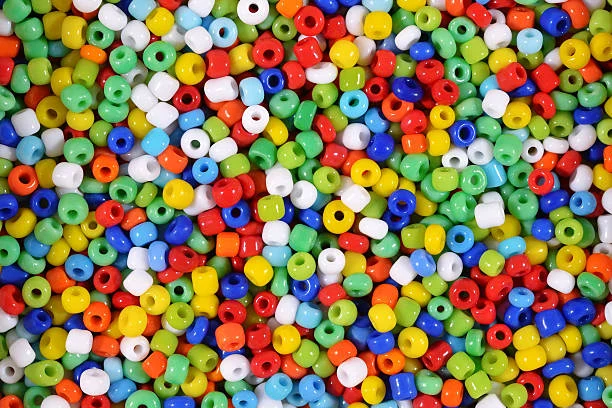A close-up view of a large pile of colorful plastic pony beads in various colors, including red, blue, green, yellow, and white.