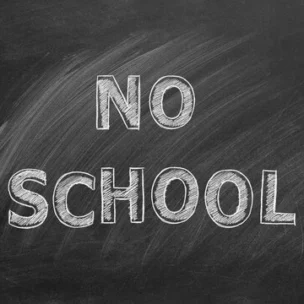A chalkboard with the words “NO SCHOOL” written in large, white chalk letters.
