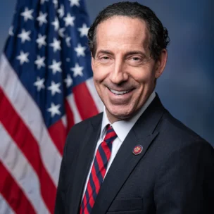Official portrait of Congressman Jamie Raskin wearing a suit and tie in front of an American flag.