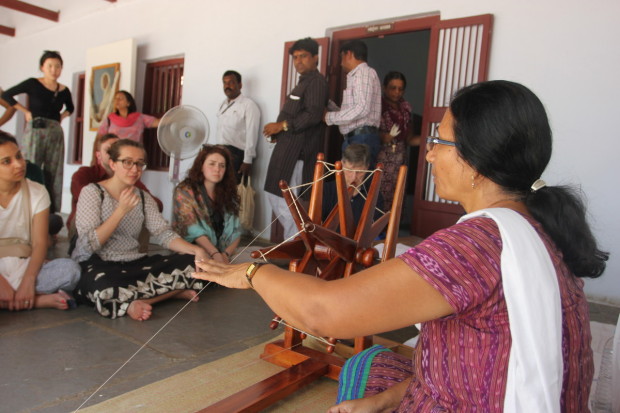 A woman demonstrates the spinning of cotton threads at the Sabarmati Ashram in Ahmedabad, India. Photo by Rachel Lowry.