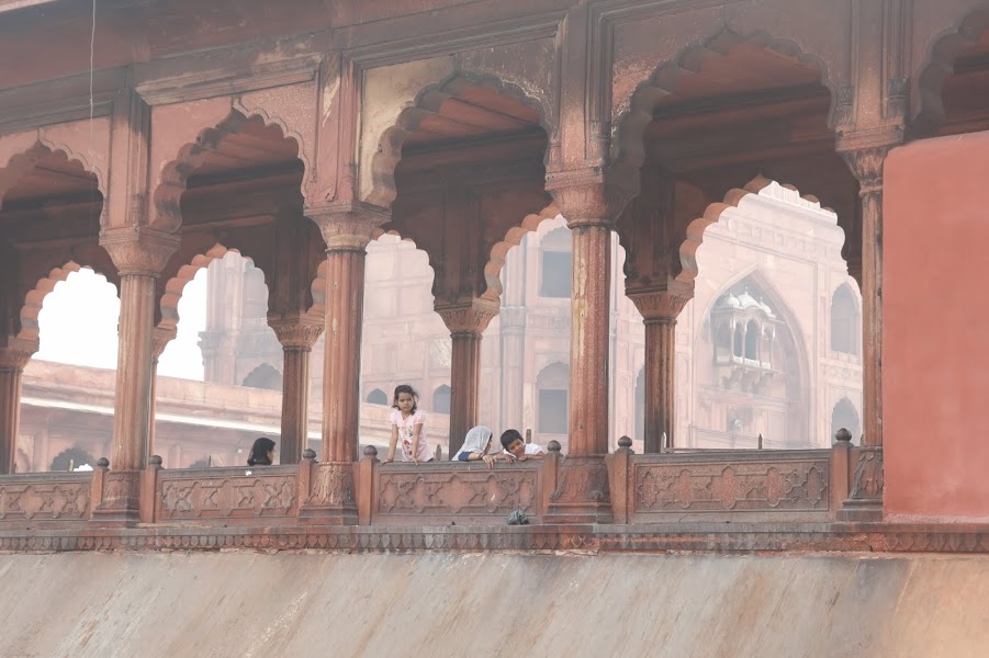Children peek out from the arches of the Jama Masjid in Old Delhi. Photo by Olivia Lace-Evans.