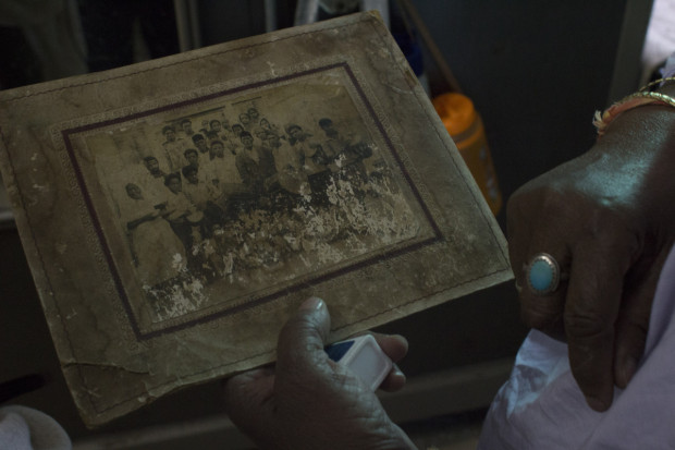 Rumanaben shows an old photo of her family members, including her mother and father. Photo by Darcy Coulter.
