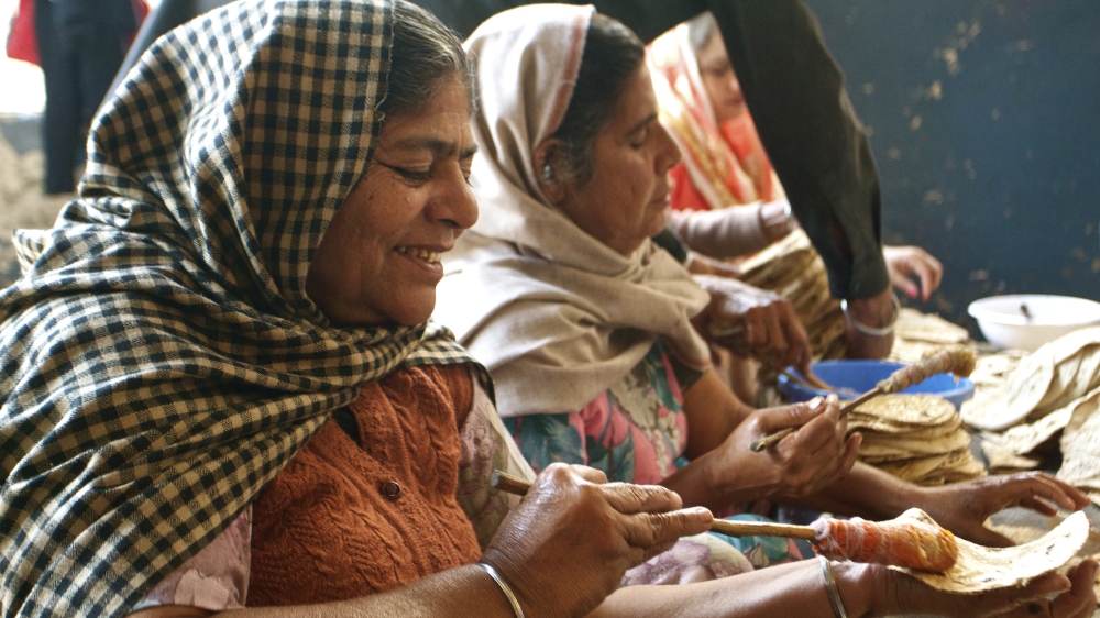 Indian women in the Golden Temple of Amritsar preparing roti, Indian bread that is common in the Jain diet. Photo by Jenna Belhumeur.