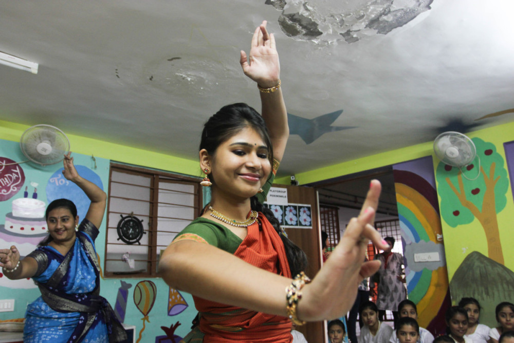 Indian women in advanced Bharatnatyam dance hold the sculpturesque Shiva Pose and accompanying facial expressions. This pose represents both the destruction and the creation of the universe, symbolizing the cycles of death, birth and rebirth.