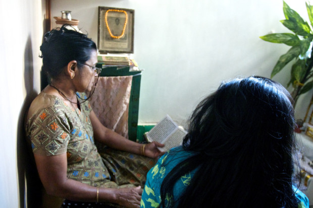 Kushboo and Privanaba Solanki sing to their murti or metal image of Lord Krishna in their home in Ahmedabad, Gujarat.