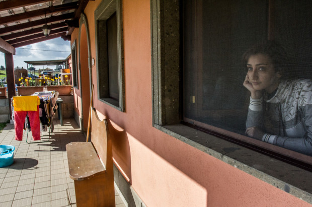 Mirvat Sayegh, 23, gazes outside of her room at the Casal Damiano guesthouse in Campoleone, Italy. Sayegh is one of the 23 Syrian refugees living at the guesthouse as part of a humanitarian mission sponsored by an ecumenical partnership between Italian Christian organizations. March 15, 2016. (Religio/Lora Moftah)