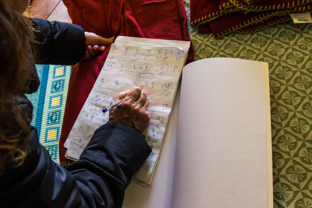 Badia Sayegh looks over a sheet of paper where she has begun practicing the Latin alphabet. Language instruction is a key part of the Waldensian Church's efforts to integrate Syrian refugees in Italy. March 15, 2016. (Religio/Lora Moftah)