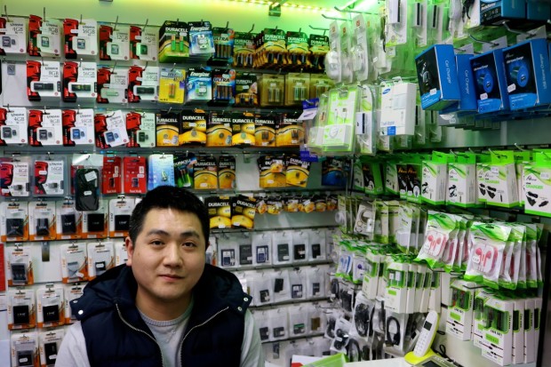 Xiaohai Zhang takes turns with his partner to work in their telephone service store.
