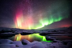 A beautiful green and red aurora dancing over the Jokulsarlon Lagoon, Iceland.