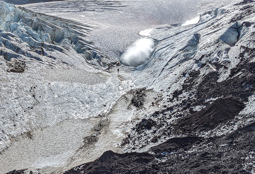 A tiny figure stands near the entrance to the Mount Meager cave. 