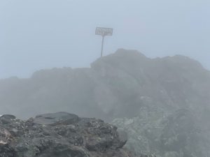 The summit of Crestone Needle in dense fog.
