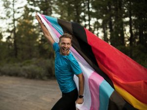 Ryan Montgomery posing with pride flag