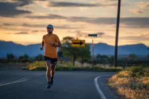Man running on beautiful road at sunrise