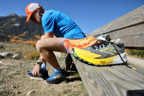 runner on bench with trail shoes at his side: Brooks Cascadia - Hoka Speedgoat - Brooks Catamount