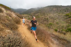 Best Beginner Running Shoes - two runners smiling while running on desert singletrack