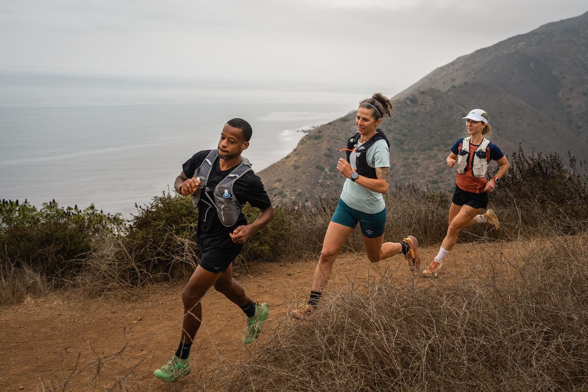 Best Running Vest - three runners in running vests on coastal trail