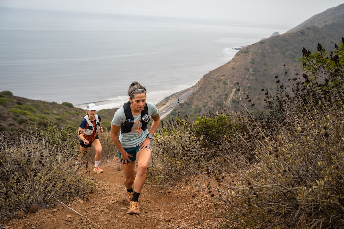 Best Running Vest - two runners hiking up climb on coastal trail overlooking ocean