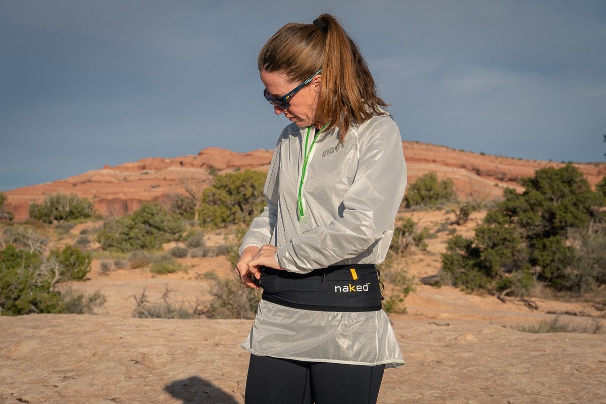 Best Running Belt - runner putting items in Naked Running Band in desert
