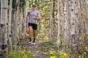 Best Road-to-Trail Shoes - runner on Colorado trail surrounded by bare trees and yellow flowers