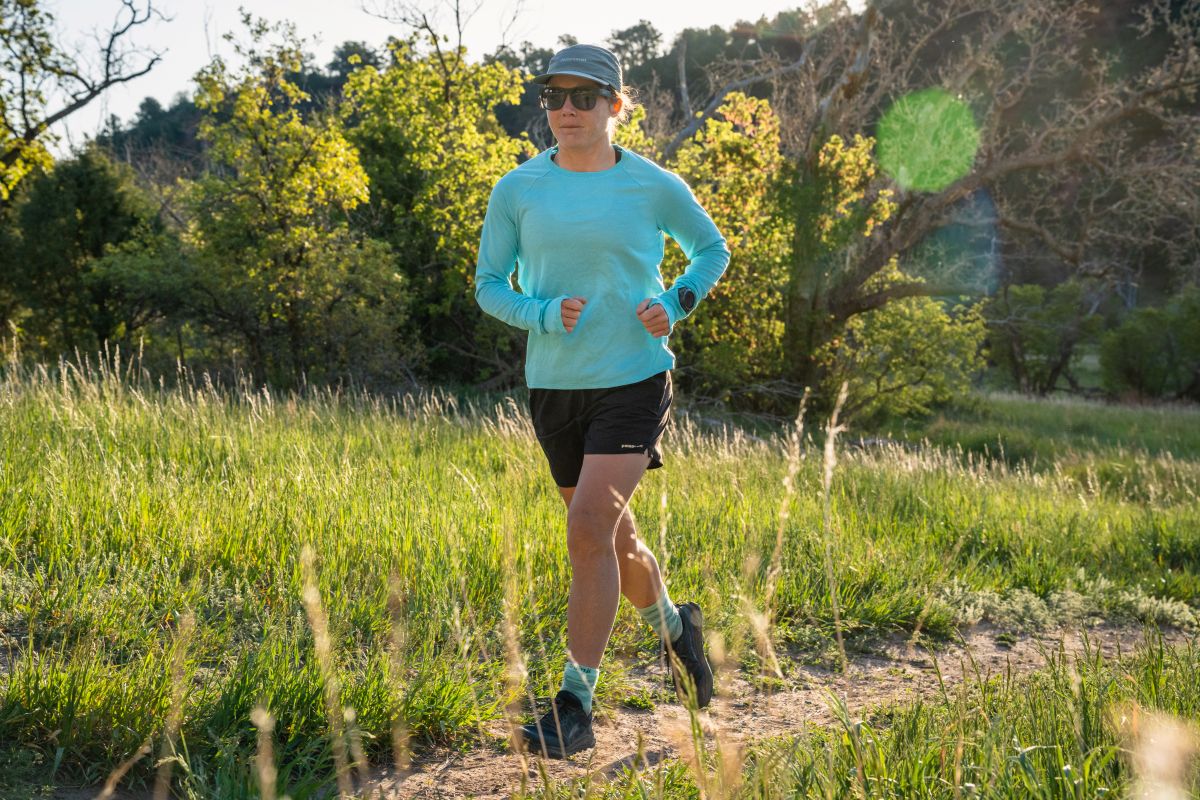 Best Running Sunglasses - runner in sunglasses on grassy, sunny trail