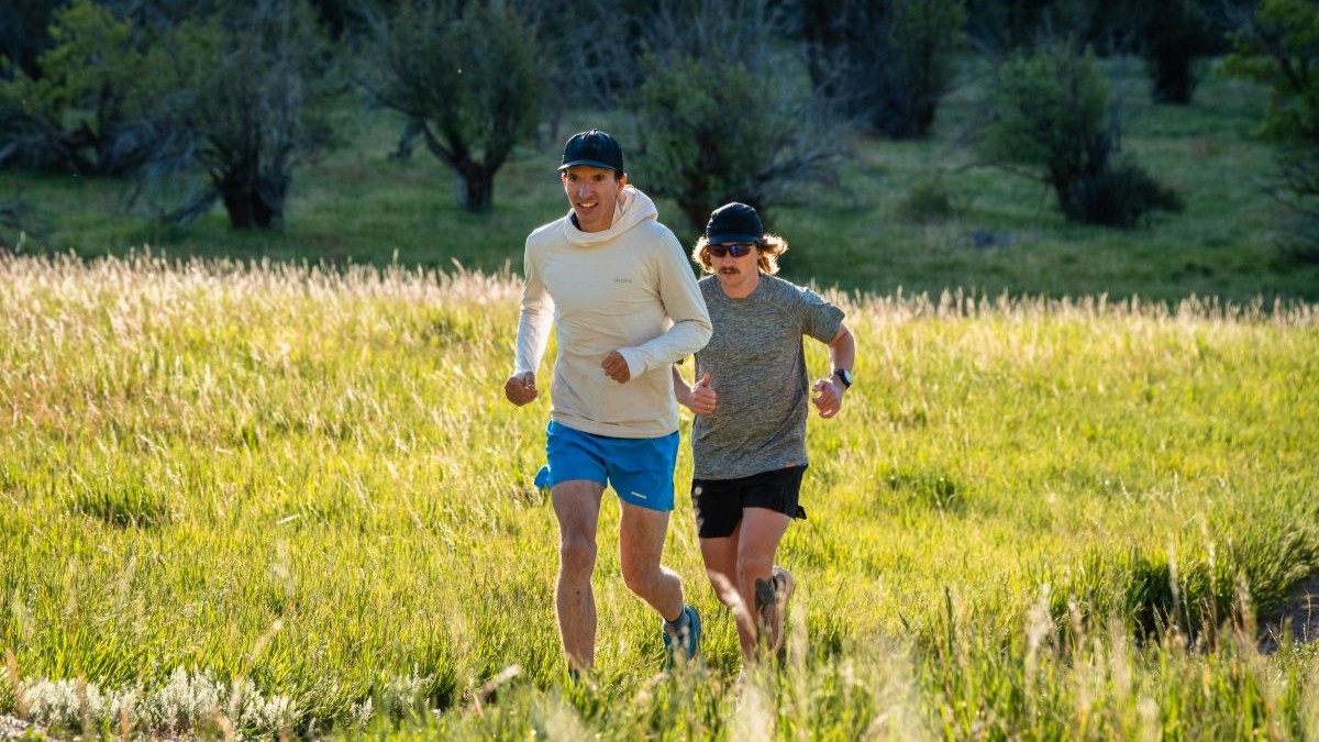 Best Running Hats - two runners in hats on grassy trail
