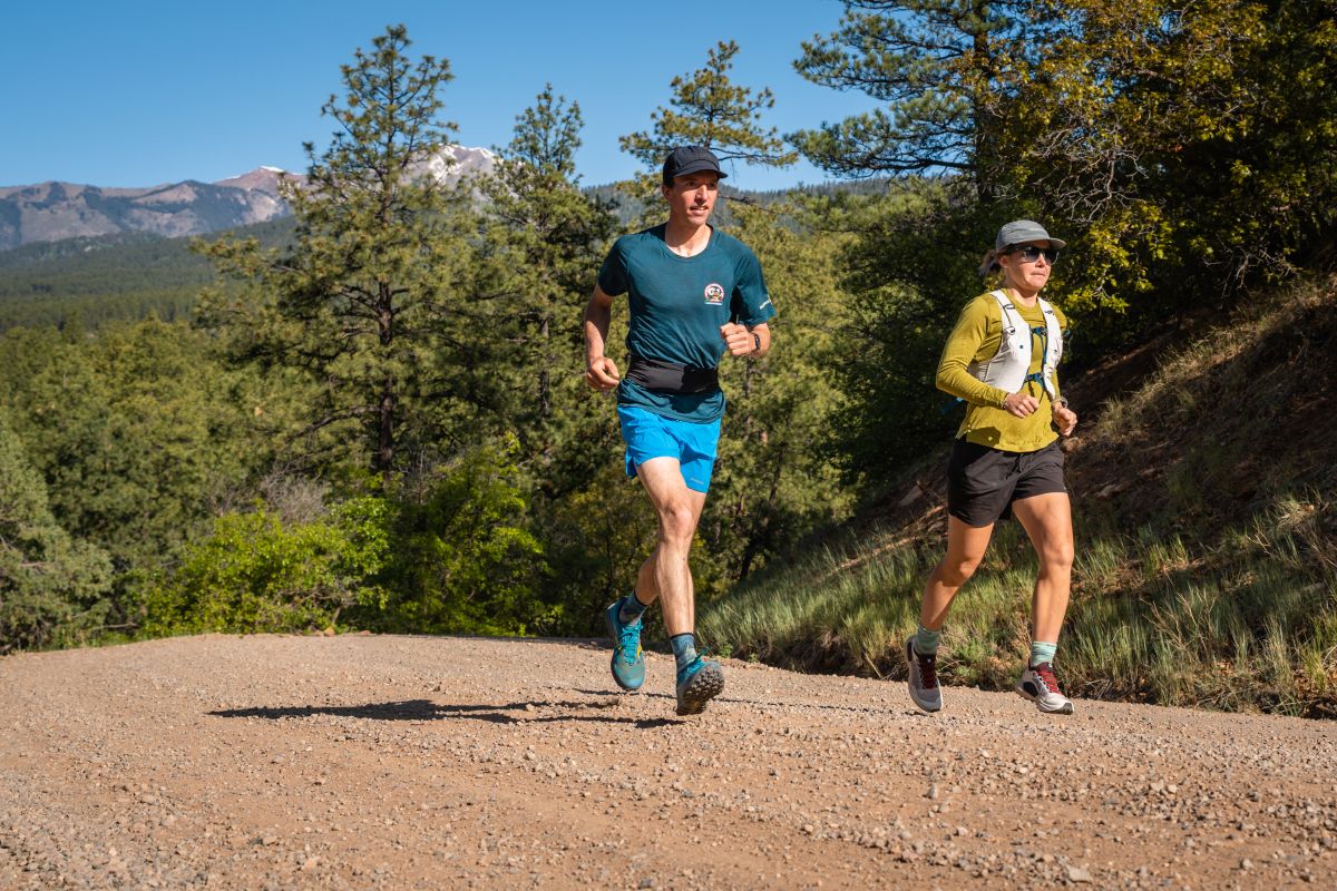 Best Running Belt - two runners, one in belt and the other in vest, running on gravel road