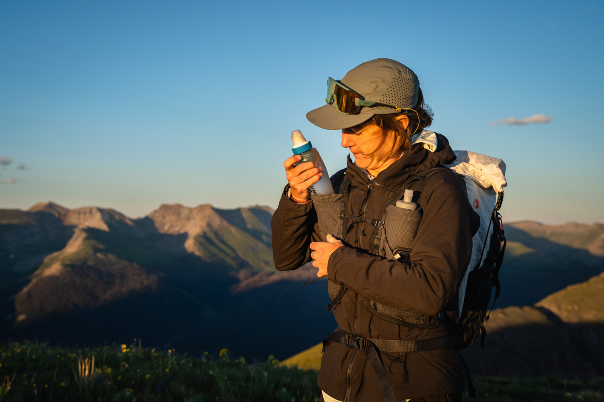 Best Water Filter for Trail Running - runner stuffing filter flask into running vest