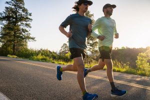 Two runners on road at sunrise