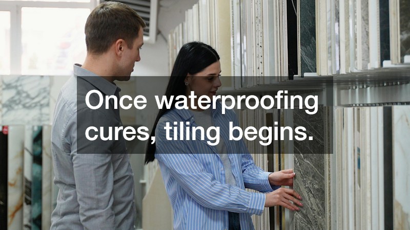 Once waterproofing cures, tiling begins.