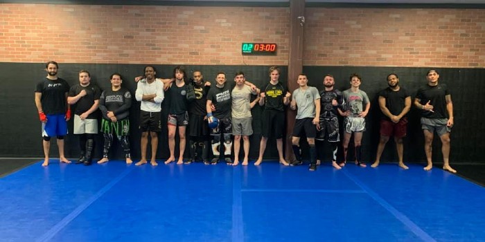 group of mma students standing against the wall