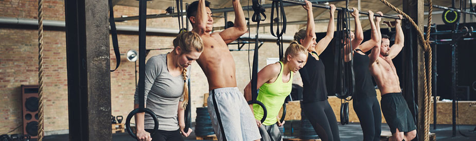 Athletes doing pull ups at gym