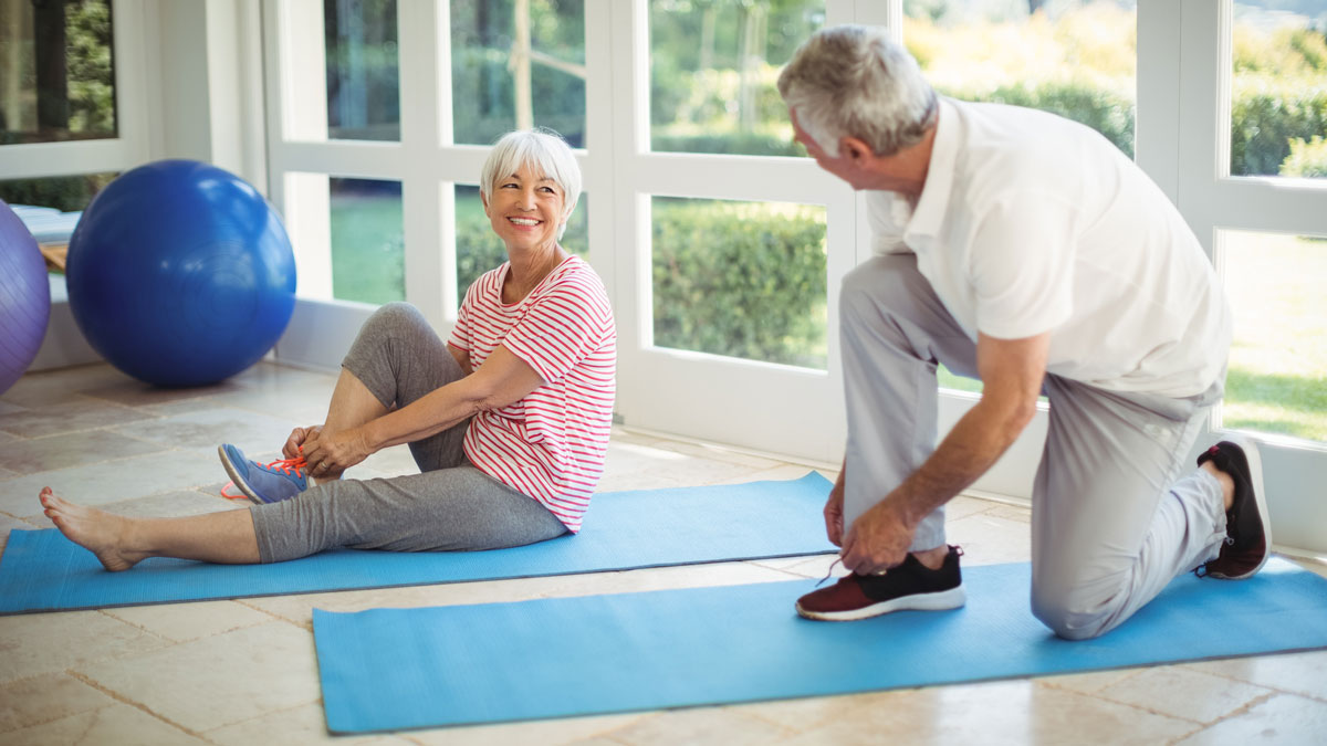 older man and woman putting on sneakers