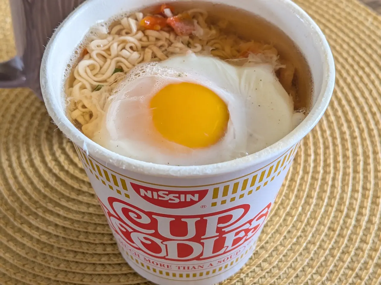 半熟の卵が乗っているカップヌードルの写真