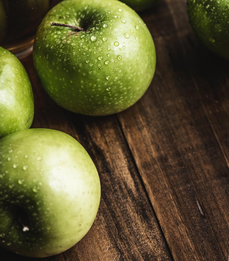 Green apples on a wooden counter