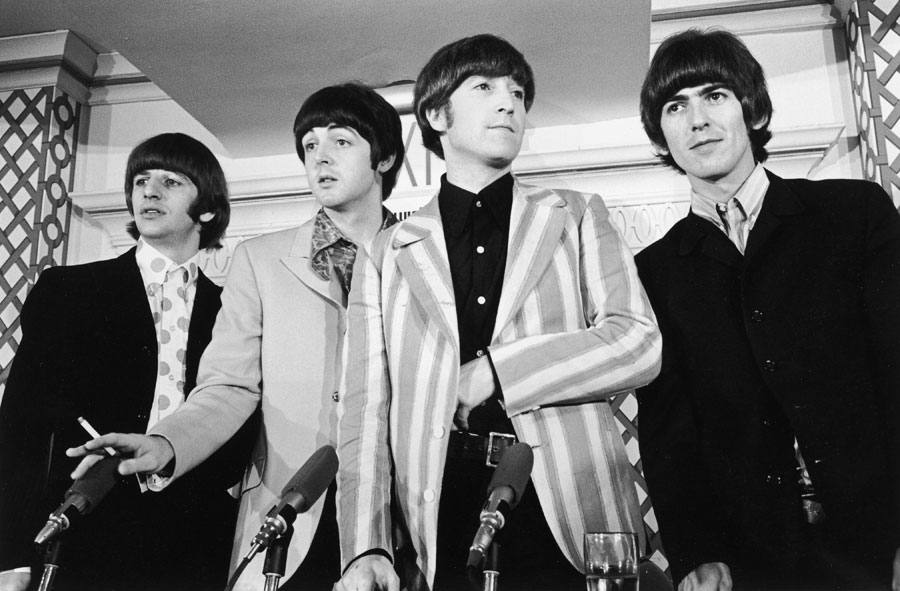 British pop group the Beatles standing in front of four microphones at a press conference where they discussed their concert at Shea Stadium, New York City. L-R: Ringo Starr, Paul McCartney, John Lennon (1940 -1980), and George Harrison (1943 - 2001).